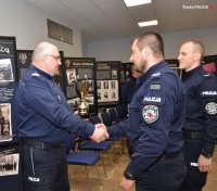Komendant Wojewódzki Policji składa gratulacje dwóm policjantom.