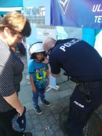 Policjant zapina kas policyjny dziecku.