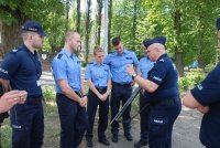 Policjant tłumaczy zasadę i warunki użycia pocisków niepenetracyjnych wystrzeliwanych z bronii gładkolufowej.