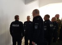 Sala odpraw. Zastępca Dowódcy Oddziału Prewencji Policji w Katowicach mł.insp. Artur Maliszewski składa meldunek Zastępcy Komendanta Wojewódzkiego Policji w Katowicach insp. Mariuszowi Krzystyniakowi