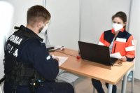 Pielęgniarka przeprowadza wywiad z policjantem Oddziału Prewencji Policji w Katowicach przed szczepieniem.