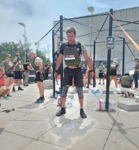 Sierżant Piotr Hrabia po zakończonej konkurencji podciągania na drążku z założoną zieloną 9 - kilogramową kamizelką taktyczną.