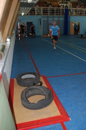 Policjant w konkurencji biegu na hali sportowej.