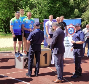 Zawodnicy Oddziału Prewencji Policji w Katowicach, którzy zajęli 2 miejsce w klasyfikacji drużynowej, odbierają gratulacje od Pierwszego Zastępcy Komendanta Wojewódzkiego Policji w Katowicach inspektora Mariusza Krzystyniaka.