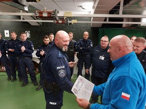 Zastępca Dowódcy Oddziału Prewencji Policji w Katowicach młodszy inspektor Artur Maliszewski wraz z Przewodniczącym Zarządu Terenowego Niezależnego Samorządnego Związku Zawodowego Policjantów Oddziału Prewencji Policji w Katowicach aspirantem sztabowym Dariuszem Tabasem wręczają pamiątkową statuetkę i dyplom za zajęcie drugiego miejsca w konkurencji instruktorów młodszemu aspirantowi Piotrowi Rozumkiewiczowi z Samodzielnego Pododdziału Prewencji Policji w Bielsku-Białej.