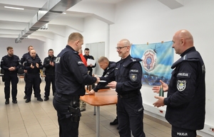 Dowódca Oddziału Prewencji Policji w Katowicach wręcza dyplom za uczestnictwo jednemu z instruktorów.