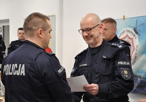 Dowódca Oddziału Prewencji Policji w Katowicach wręcza pamiątkowy dyplom kapitanowi jednej z drużyn.