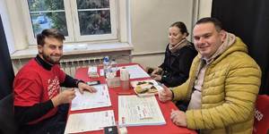 Były funkcjonariusz z żoną przy stole przed wypełnieniem ankiety do wymazu.